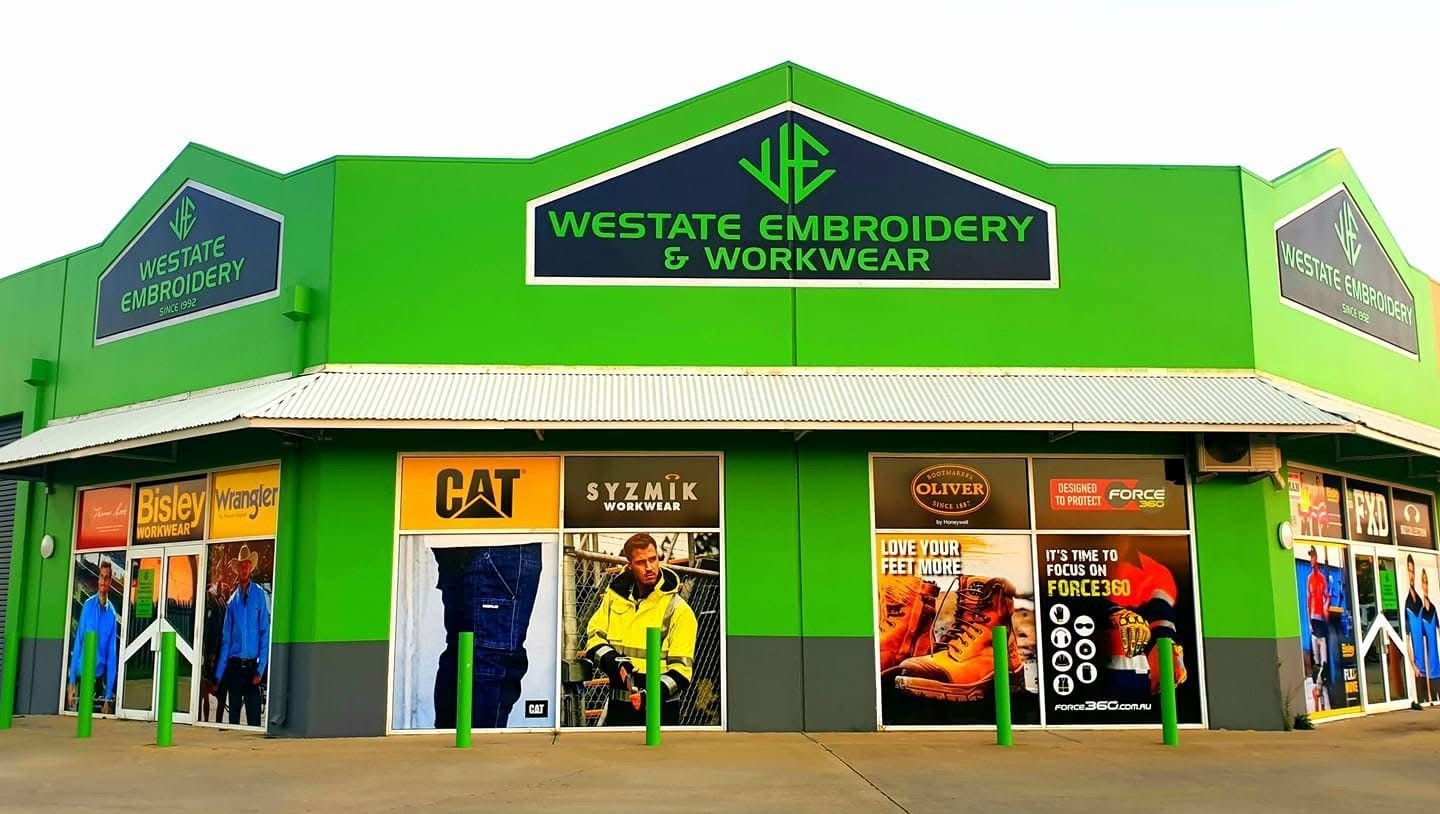 Green Westgate supermarket storefront with signs and glass entrance, people standing outside
