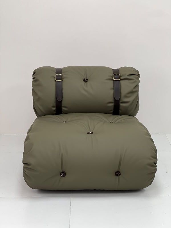 Olive green, padded chair with tufted buttons and leather straps.
