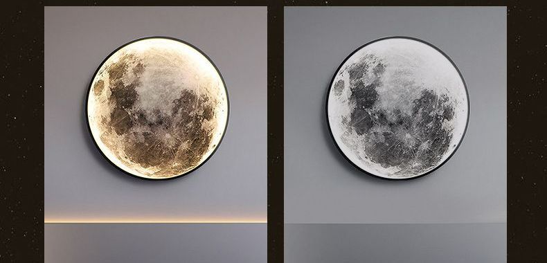 Two moon-shaped wall lamps. One is lit with a warm glow, the other is unlit. Both are set against a gray backdrop.