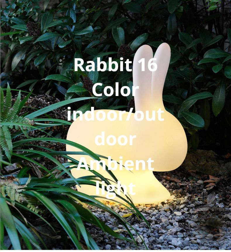 Rabbit-shaped outdoor lamp emitting ambient light with 16 color options, set in a garden with greenery.