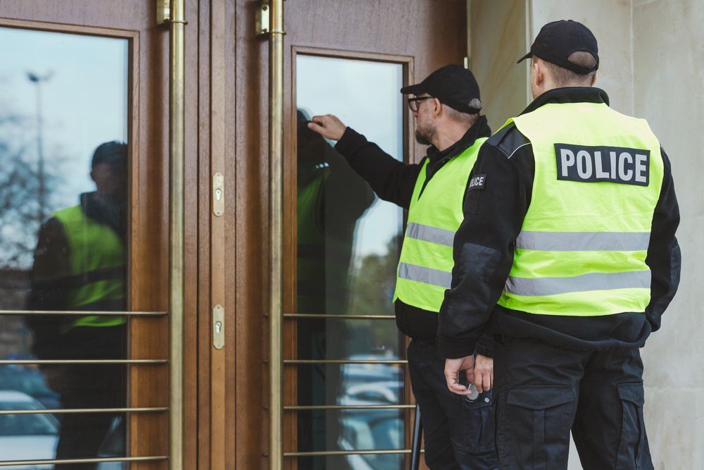 Two Police Officers Are Standing in Front of a Door — CTE Systems In Gloucester, NSW