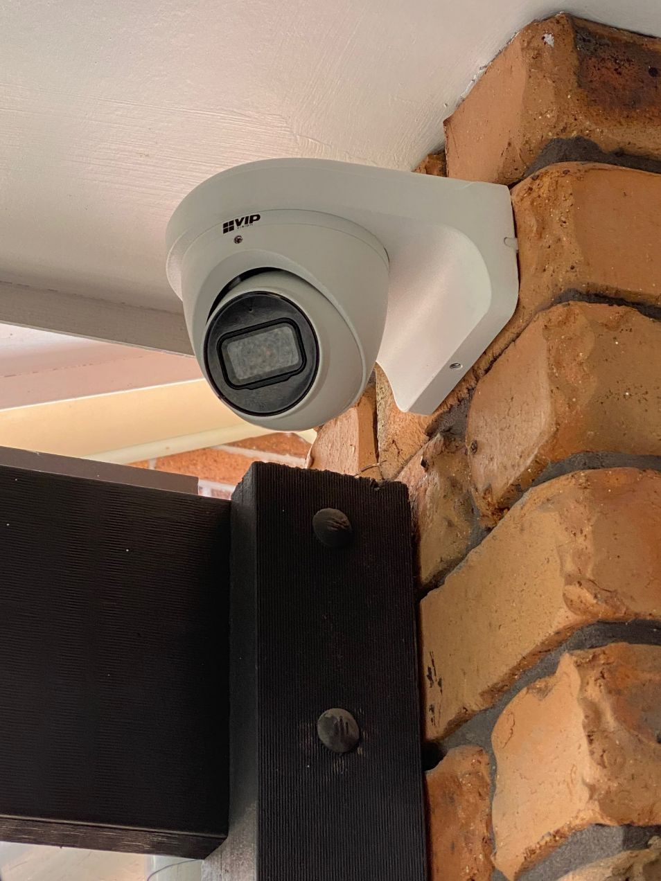A Security Camera is Mounted on a Brick Wall — CTE Systems In Tuncurry, NSW