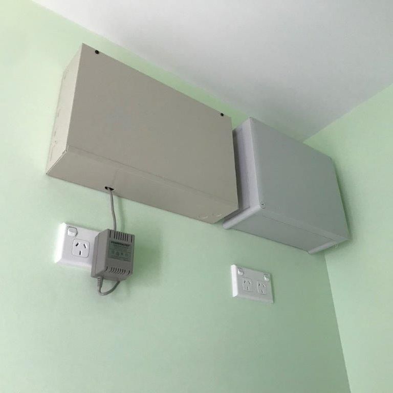 Two Electrical Boxes Mounted on a Green Wall — CTE Systems In Tuncurry, NSW