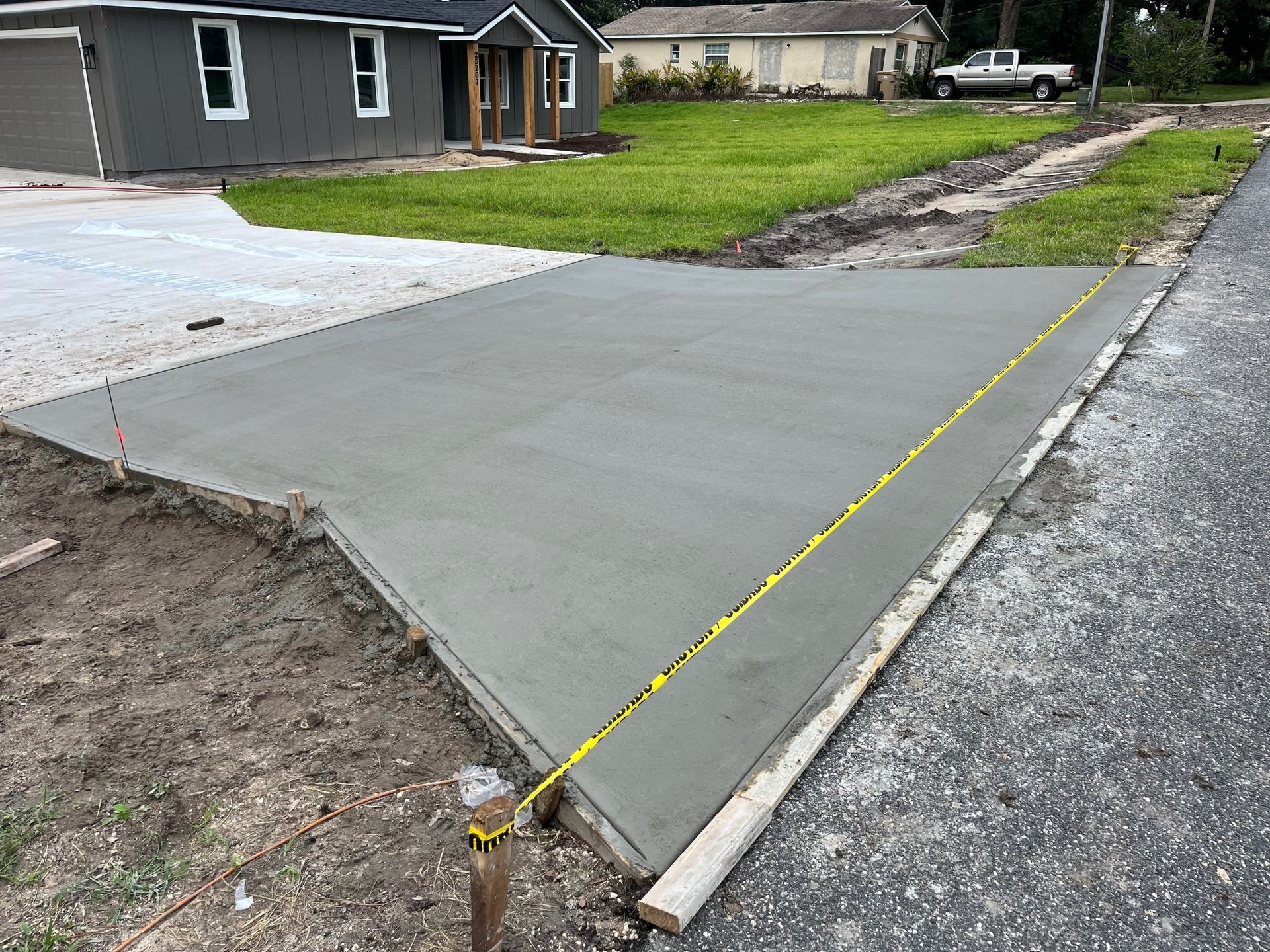 A concrete driveway is being built in front of a house.