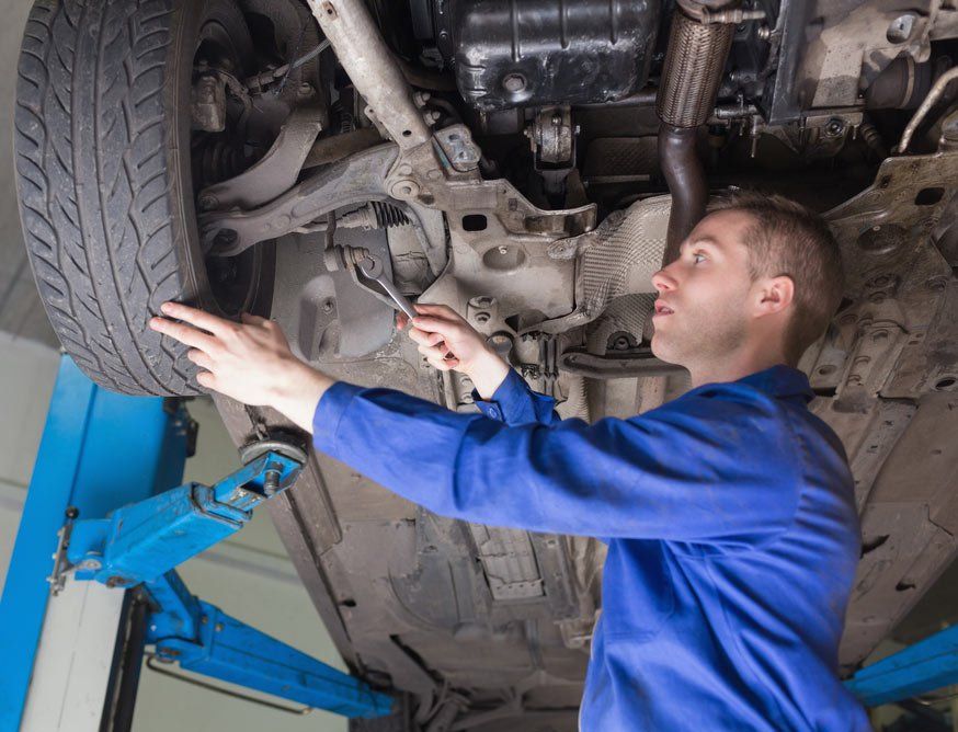 Side View Of Male Mechanic Repairing Car — Airlie Beach Exhaust and Mechanical In Airlie Beach QLD