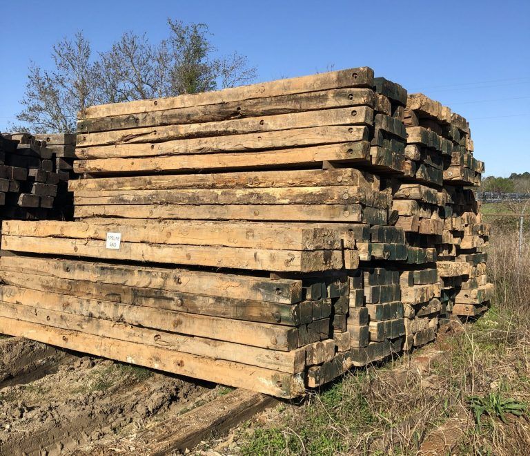 Stack of mats in east tx beams in a grassy outdoor yard under a clear blue sky