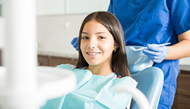 A young girl with braces is sitting in a dental chair. happy couple after visiting the dentist