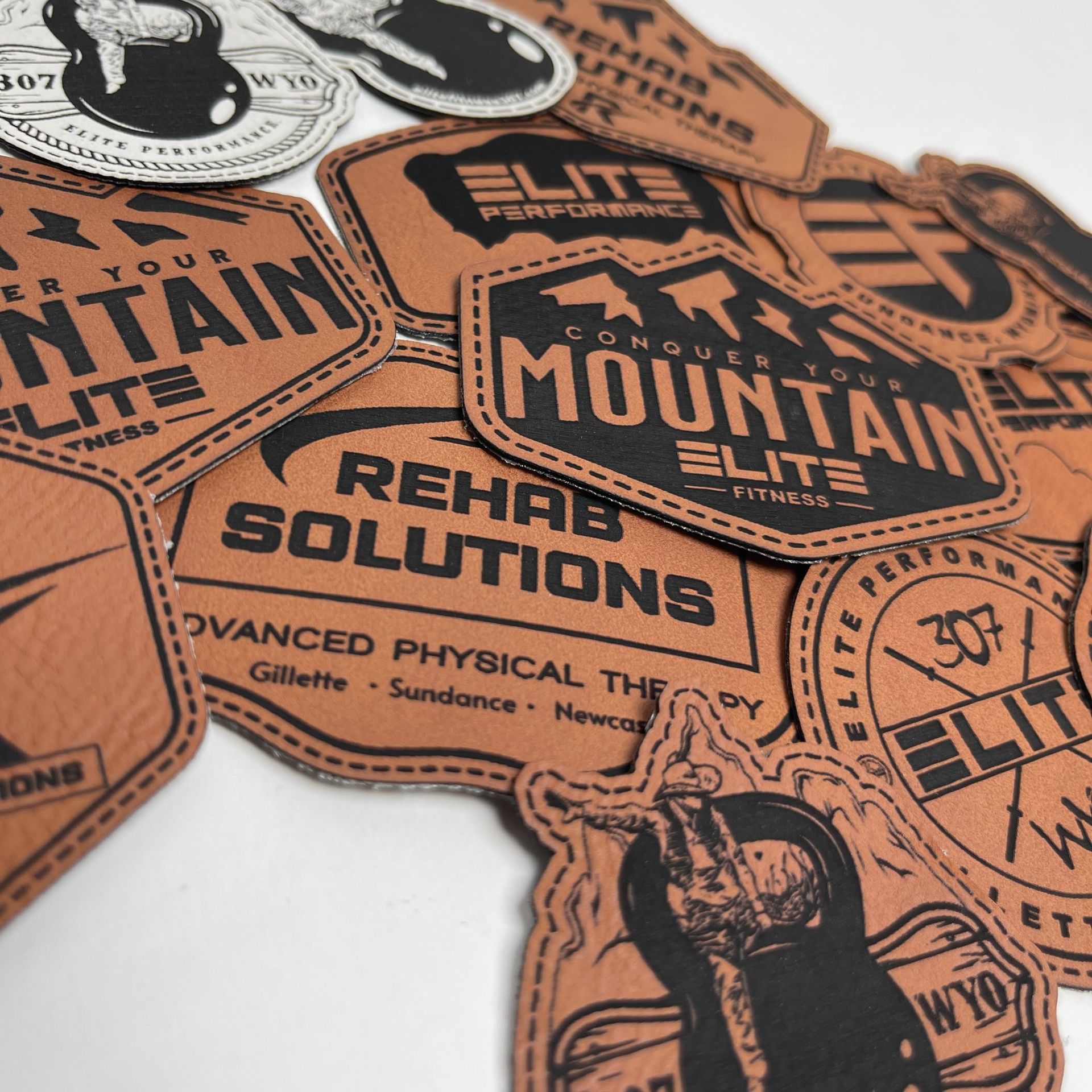 A pile of leather hat patches with one that says rehab solutions