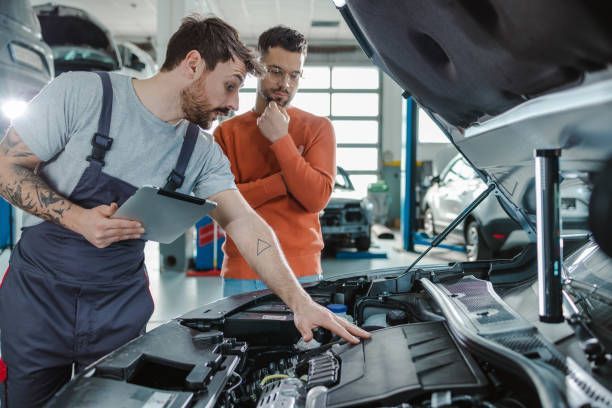 Mechanic explaining engine repairs to a customer