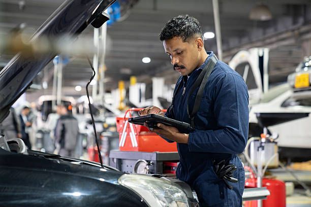 Auto mechanic checking data on a digital tablet