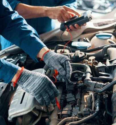 Mechanic testing a car electrical system with multimeter