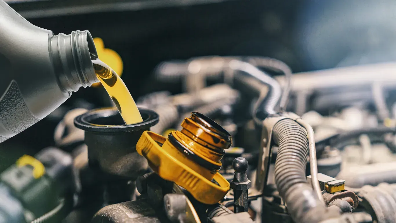 Pouring fresh engine oil during a routine oil change