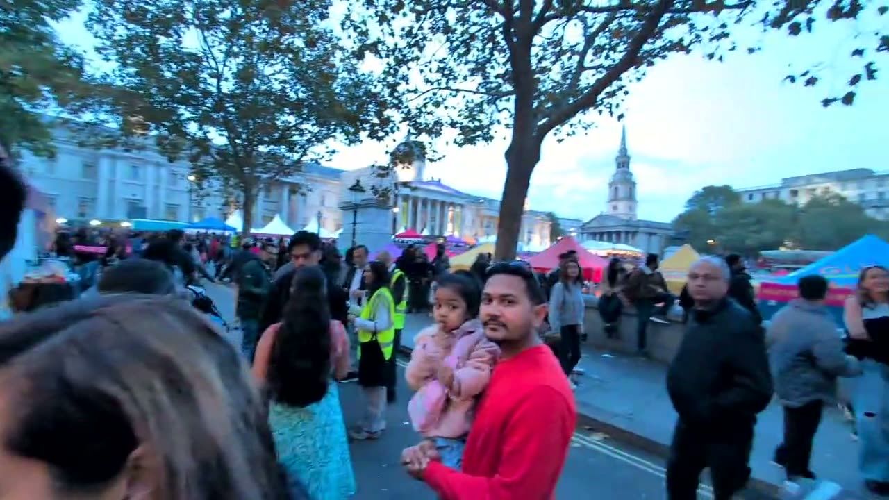 Visitors arriving at Trafalgar Square at dusk, with the National Gallery behind