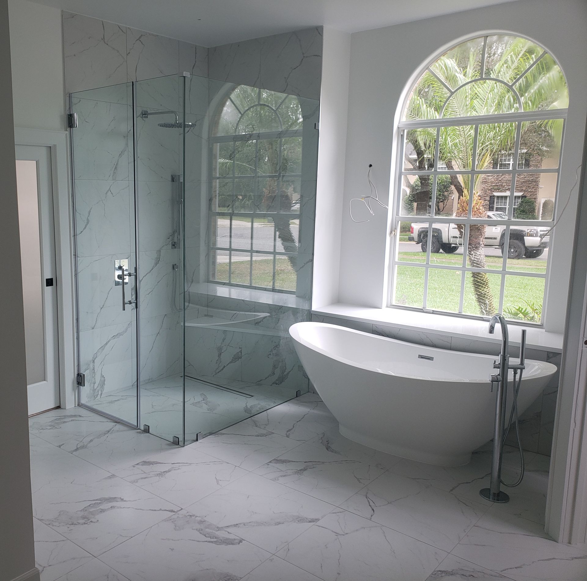 A bathroom with a tub , shower and window