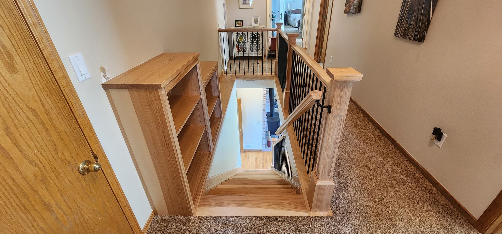 Wooden staircase with dark railing and patterned runner in a home interior