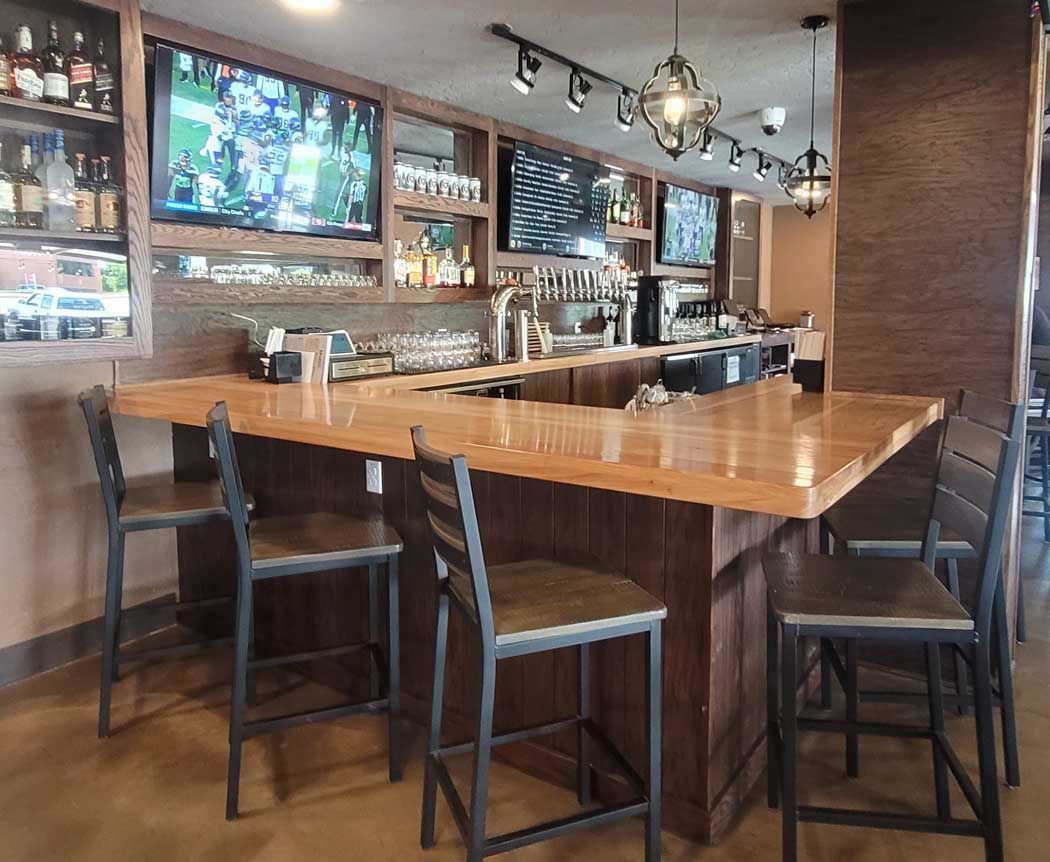 A restaurant with tables and chairs and a fire extinguisher on the wall.