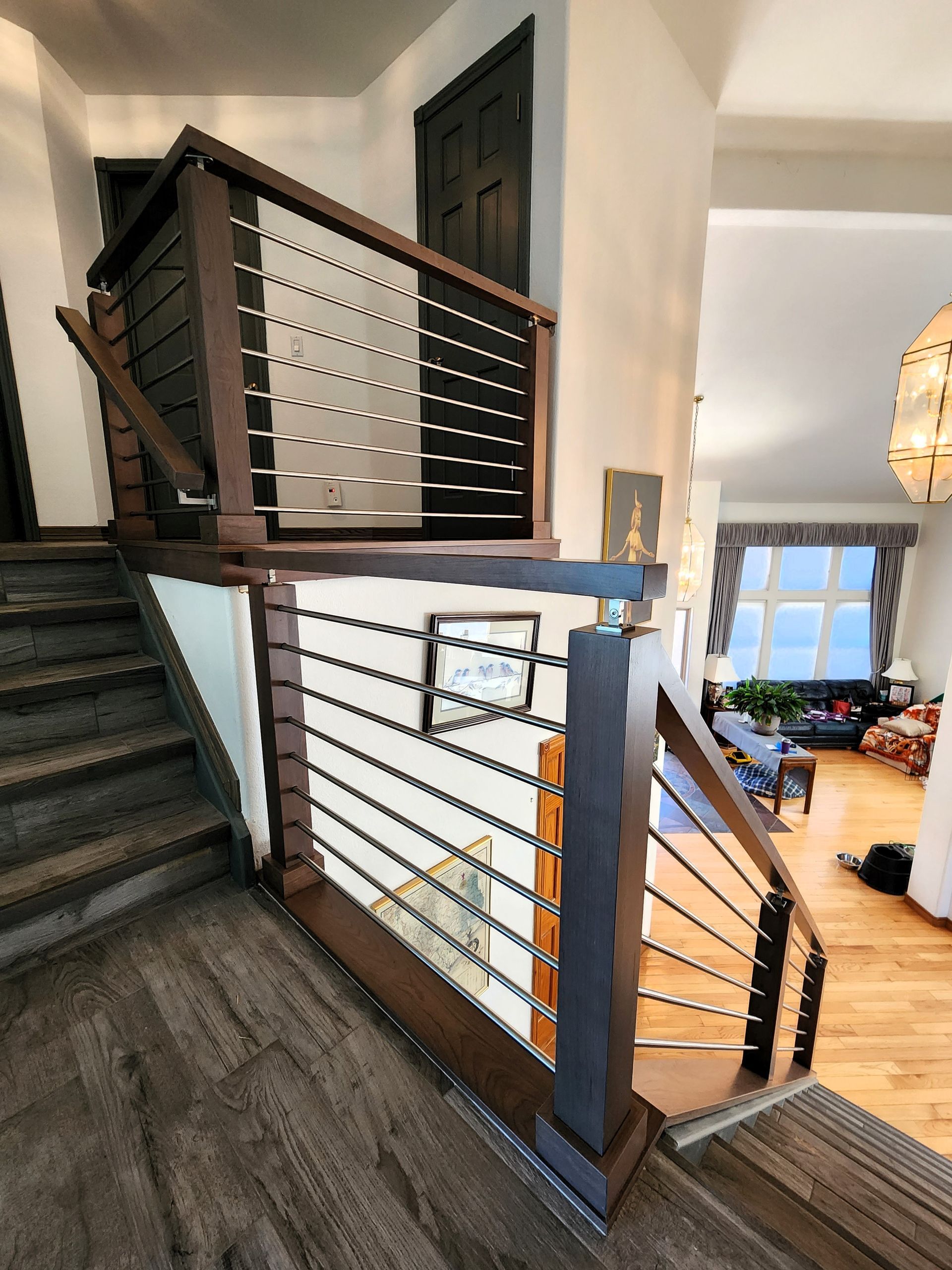 Staircase with wooden railing and metal bars, leading to a home's upper level.