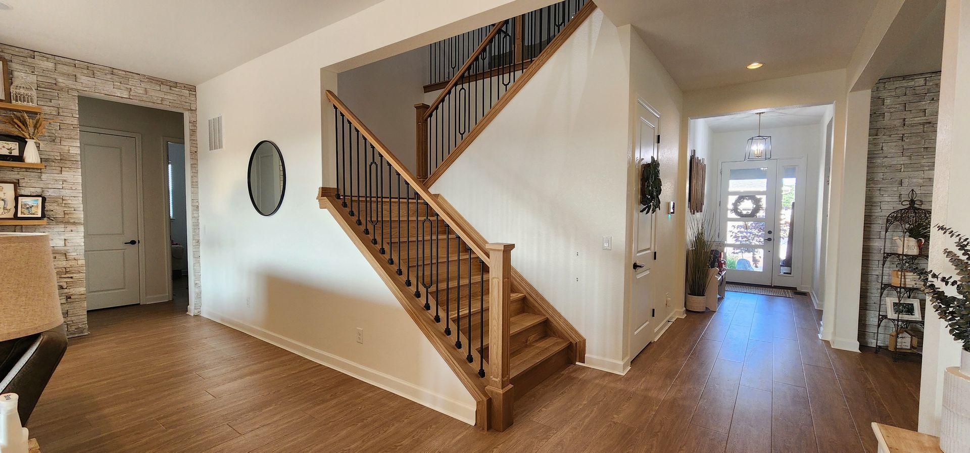Interior hallway with a staircase, door and a wooden floor.