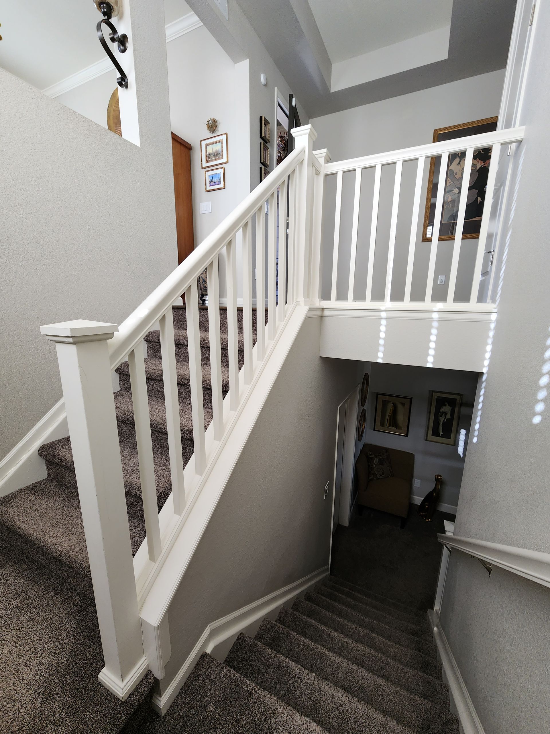 Staircase with white railing and carpeted steps in a house.