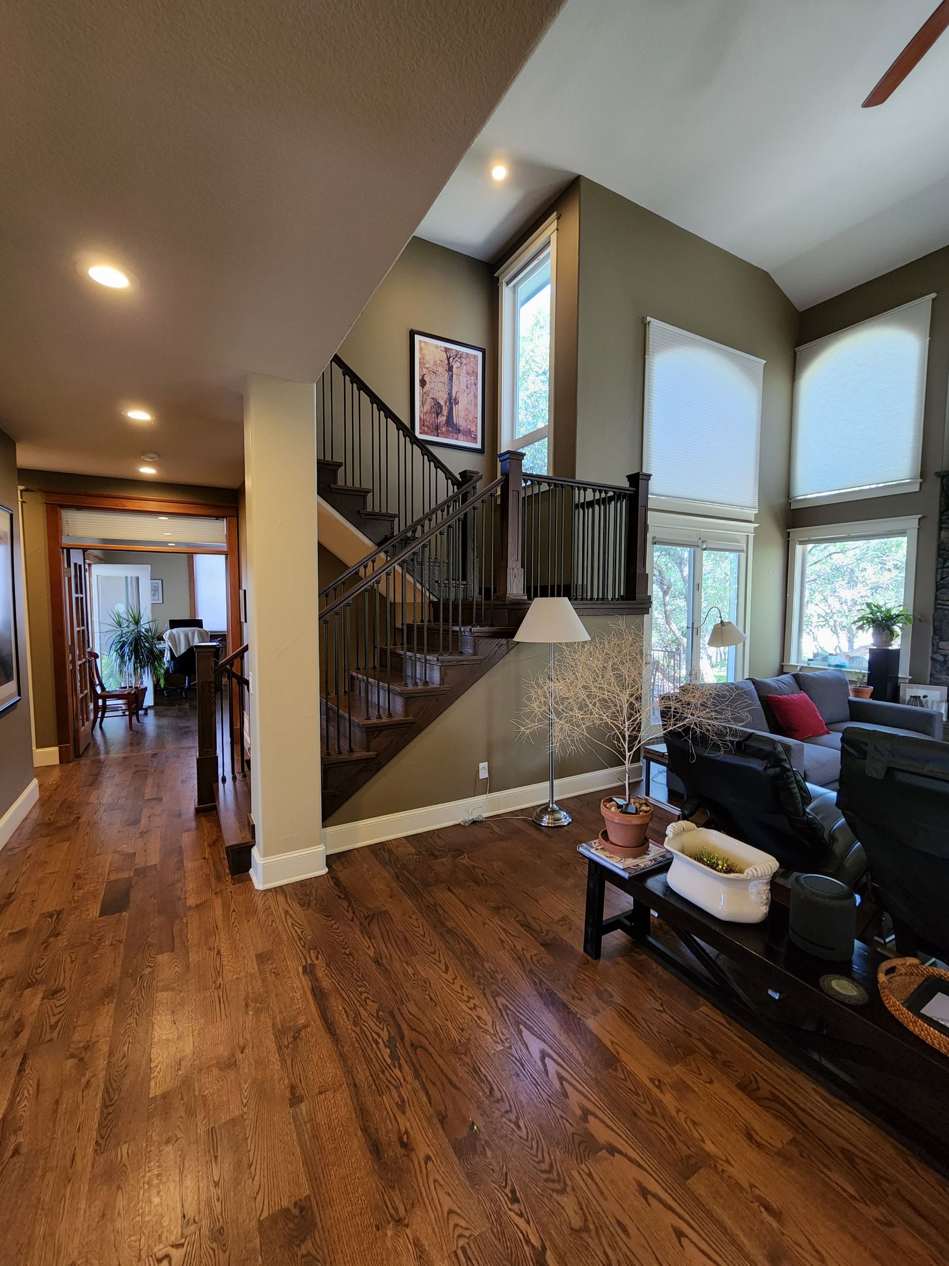 Interior view of a house with a staircase, hardwood floors, and a living room.