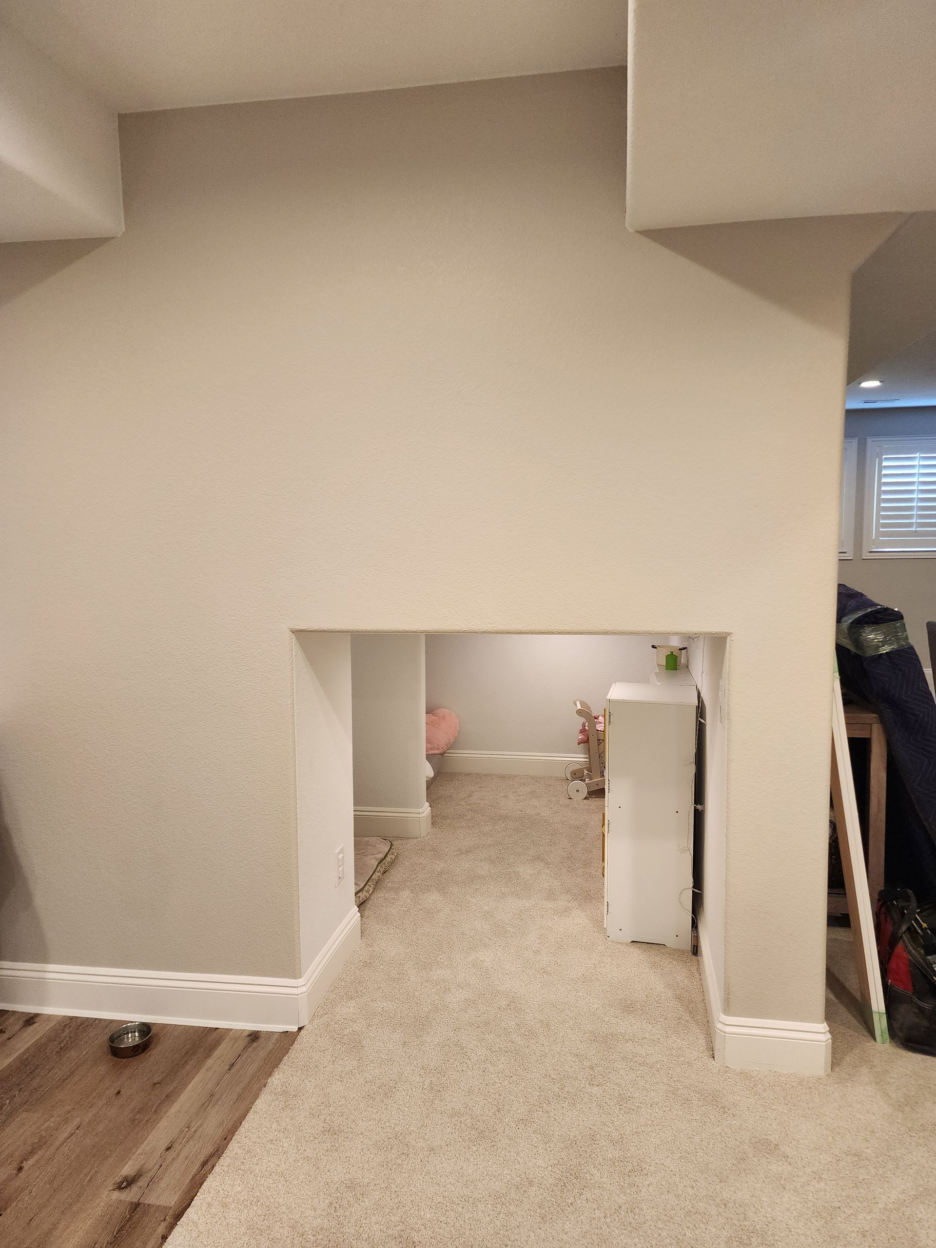 Interior view of a doorway leading to a carpeted room; neutral wall color with white trim.