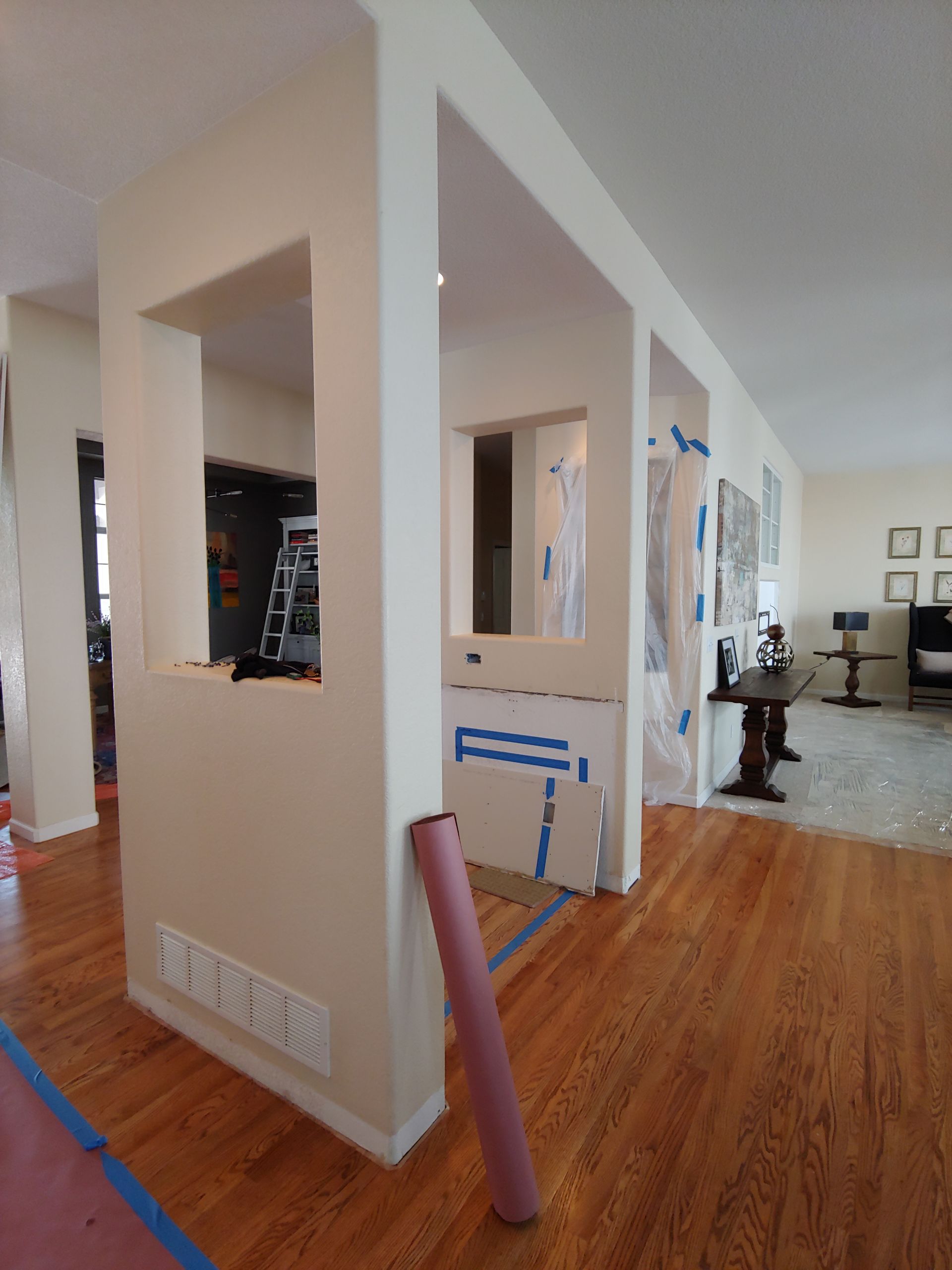 Interior view of newly painted walls with pass-through openings, over hardwood floors.