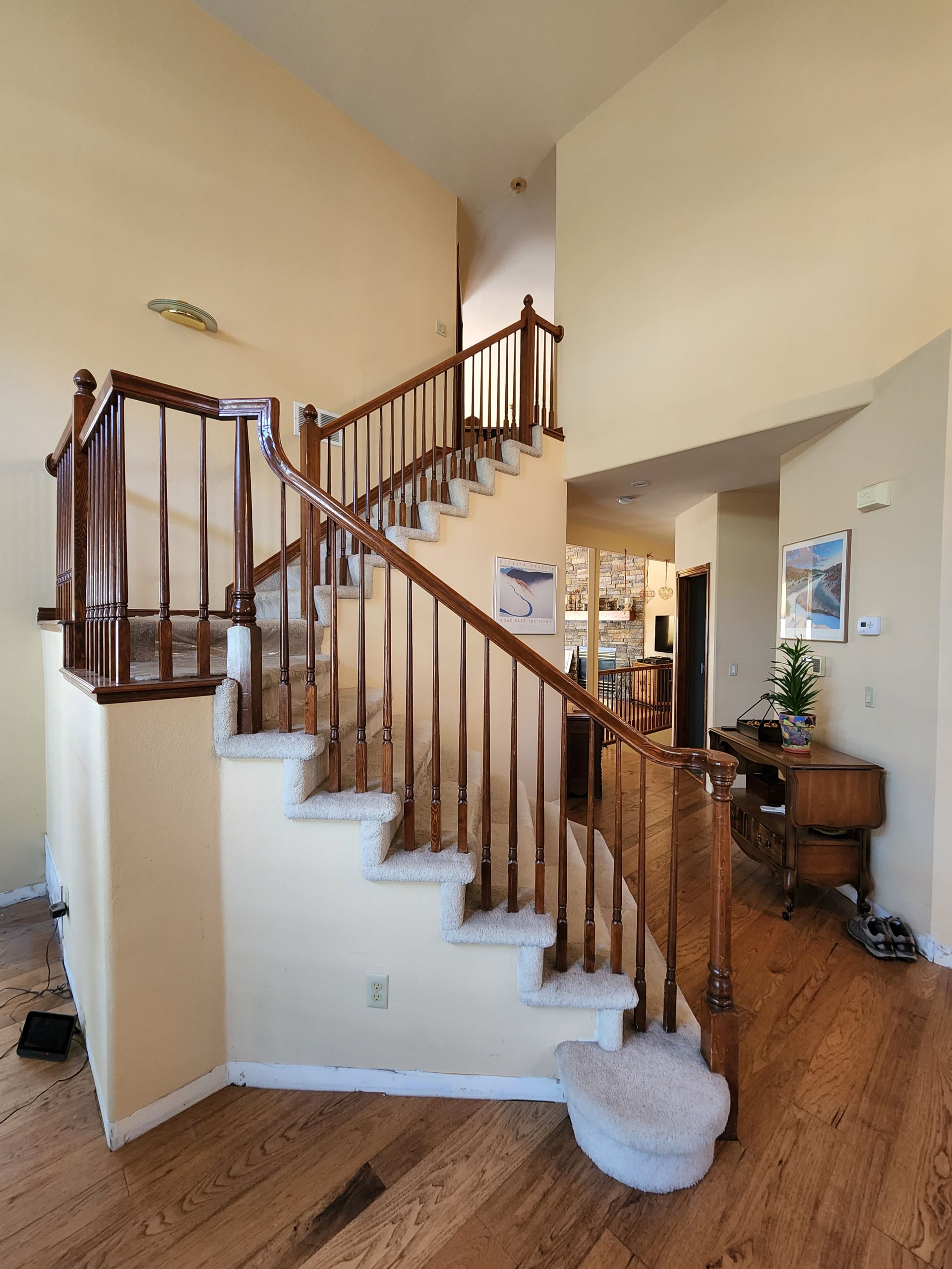 Wooden staircase with carpeted steps in a home, leading upwards.