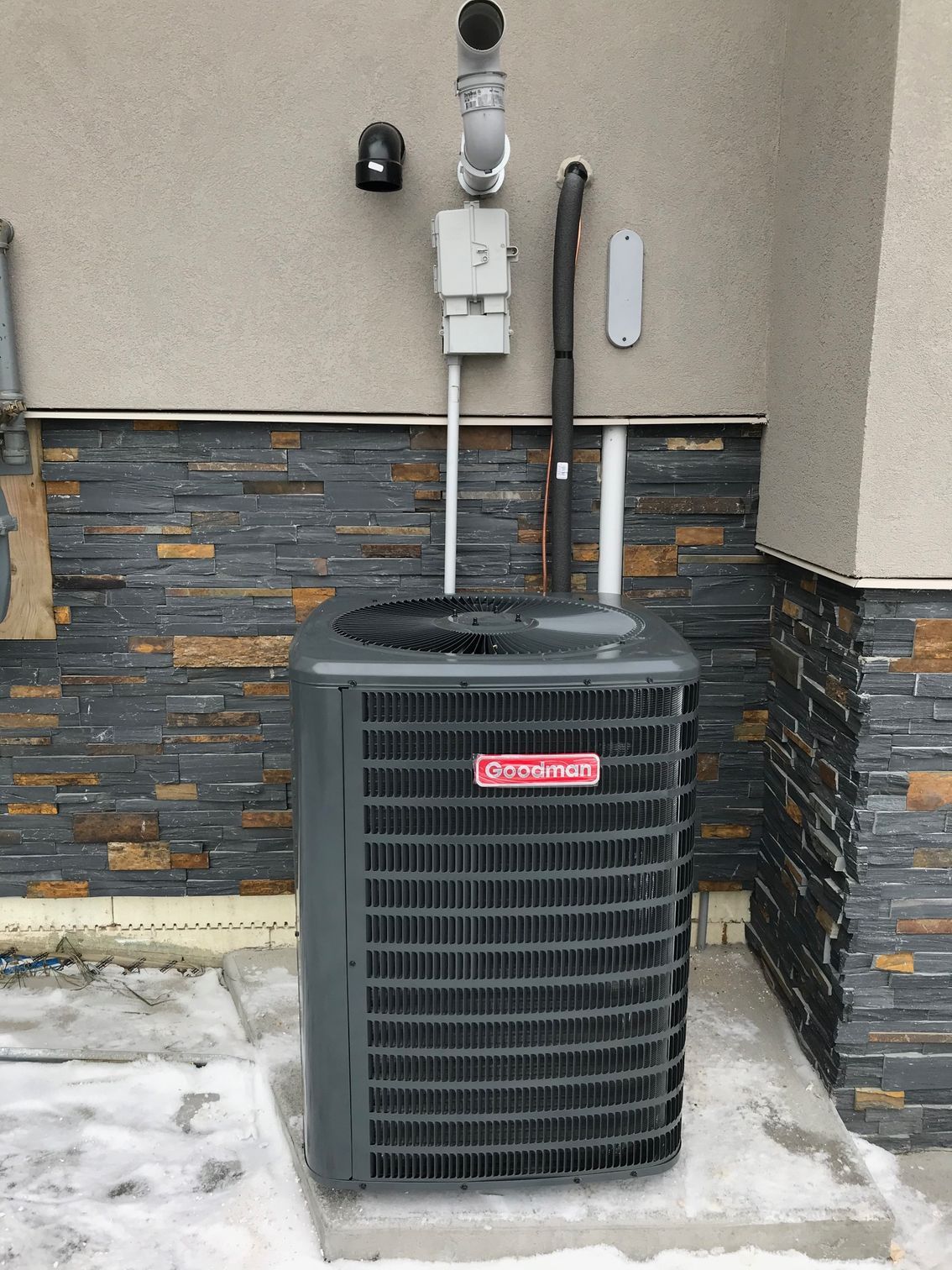 An air conditioner is sitting outside of a brick building.