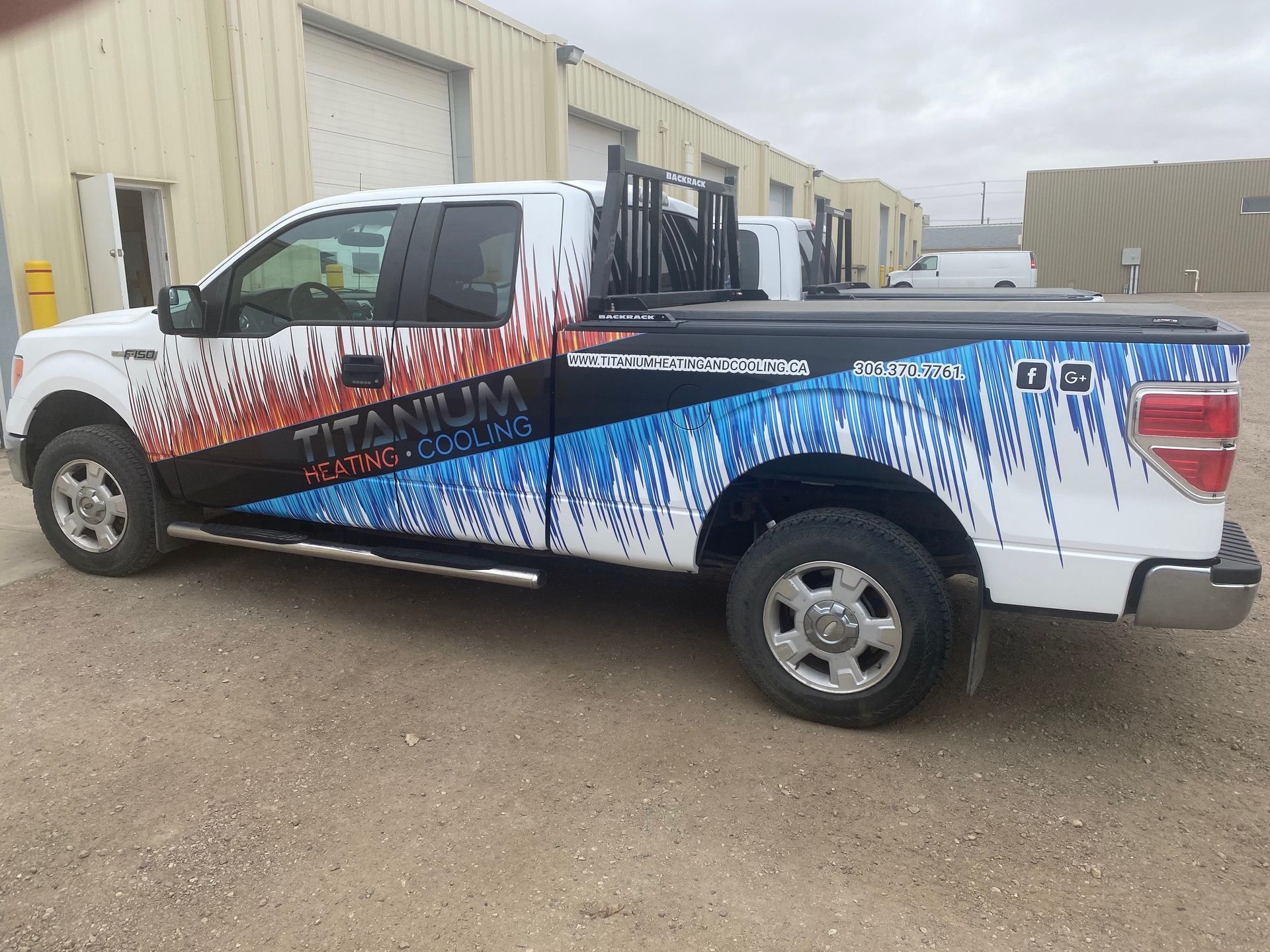 A titanium truck is parked in front of a building.
