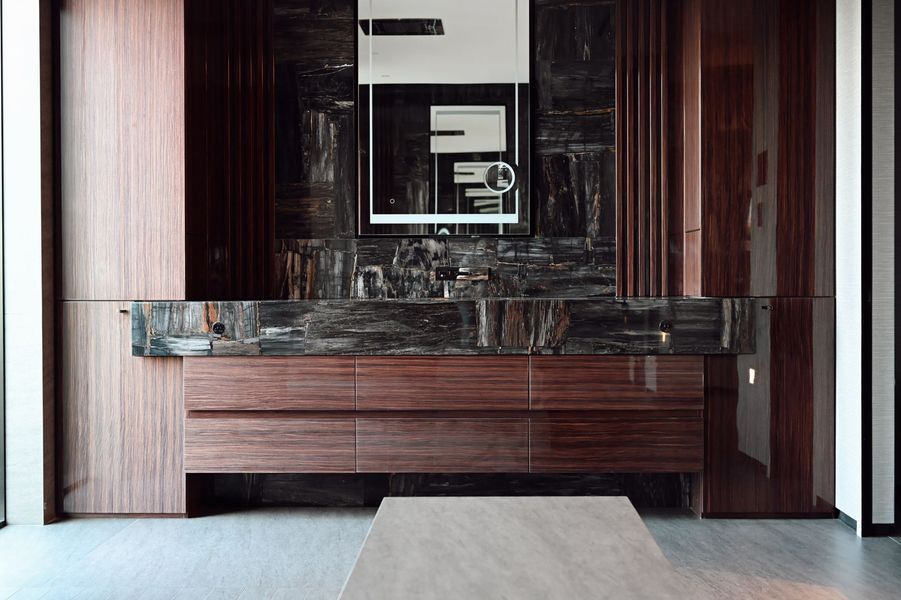 Modern wood-paneled interior with a stone fireplace and a low bench in a minimalist room