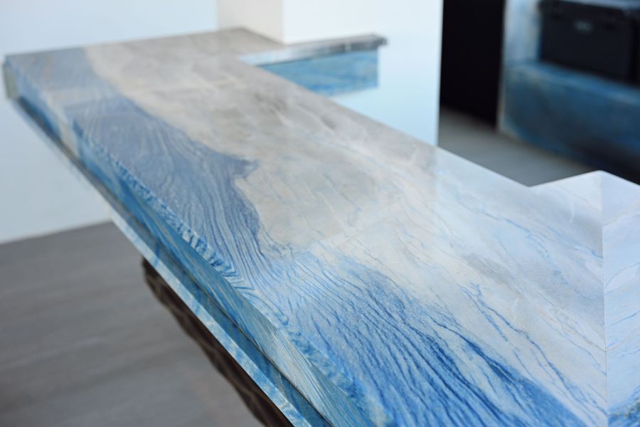 Transparent blue resin bench with wave-like wood grain texture on a tabletop