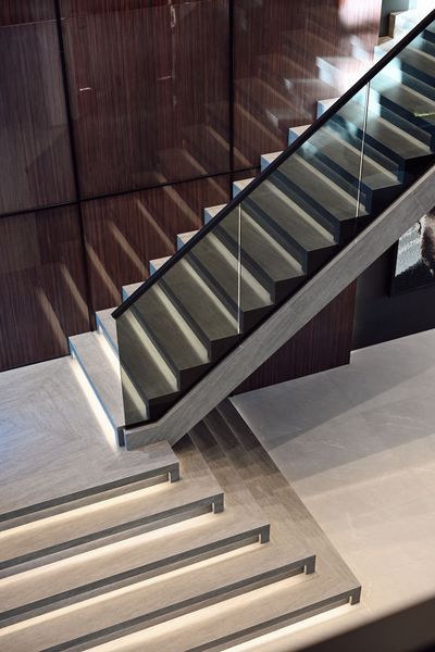Modern indoor staircase with black railings and light stone steps in a sleek lobby
