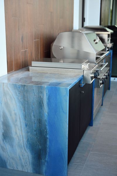 Modern stainless-steel food machine beside blue counters in an indoor workspace