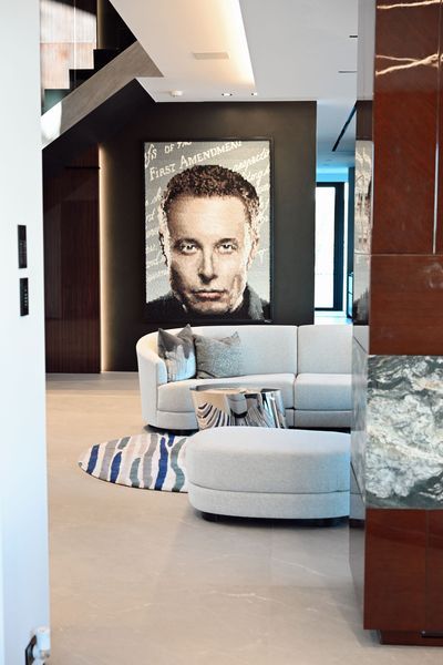 Modern living room with a large portrait, light sofas, and a striped rug