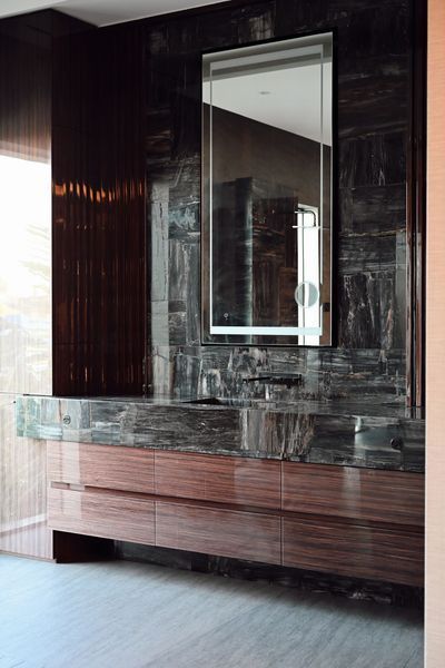 Modern bathroom vanity with dark wood cabinet, marble countertop, and large wall mirror