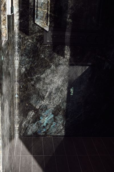 Dark narrow hallway with worn walls, tiled floor, and dim light