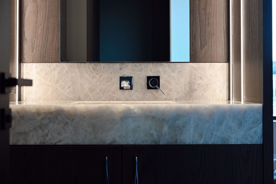Modern interior with wood paneling, backlit wall, and two small wall-mounted controls or outlets