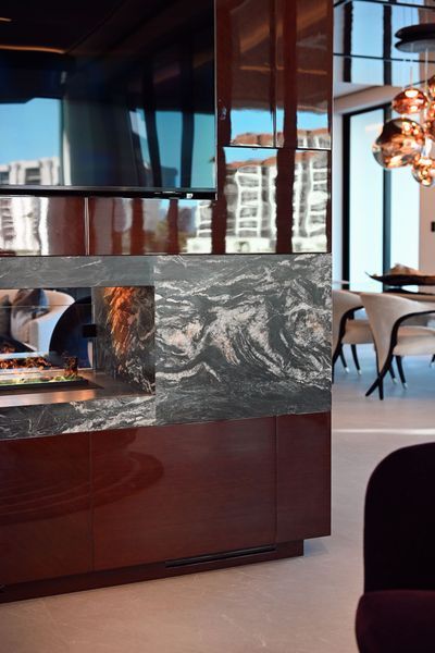 Modern lounge with marble counter, large windows, and a person seated in the background