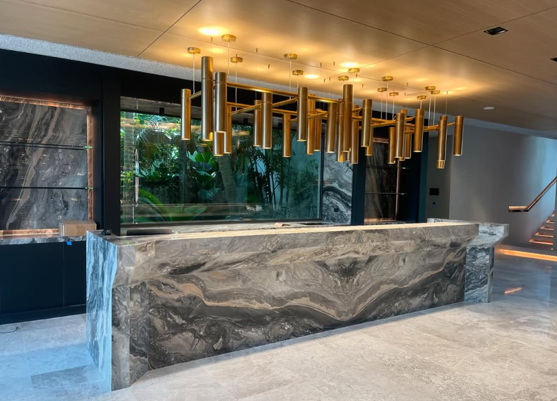 Modern hotel lobby with a marble reception desk and gold pendant lights