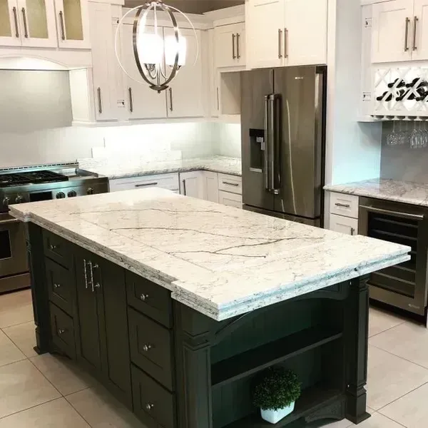 Modern kitchen with white cabinets, stainless steel appliances, and a large marble-topped island