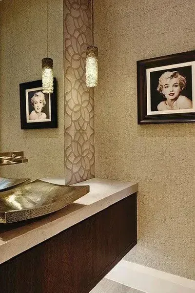 Modern bathroom vanity with beige walls, gold sink, mirrored panel, and framed art on the wall