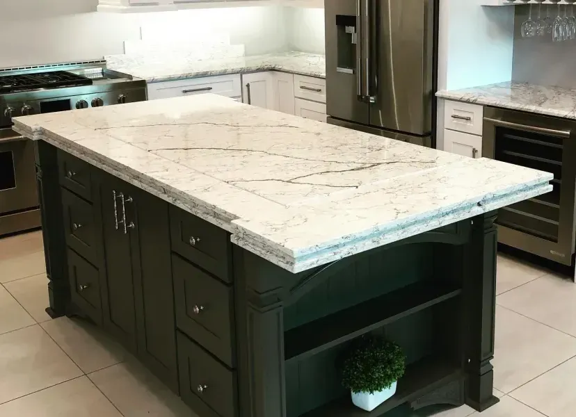 Kitchen island with white marble countertop and dark cabinets in a modern kitchen