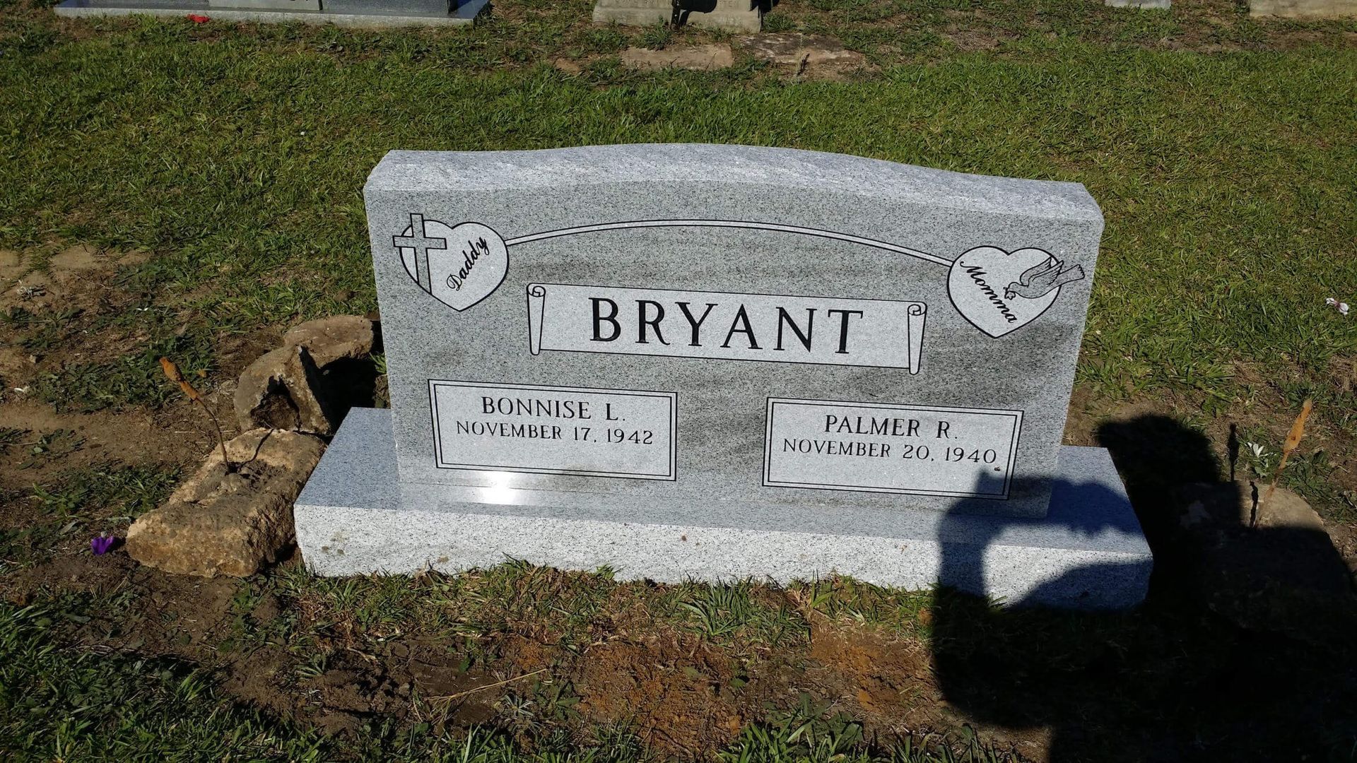 Headstone of the Bryant family, gray granite, set in a grassy cemetery.