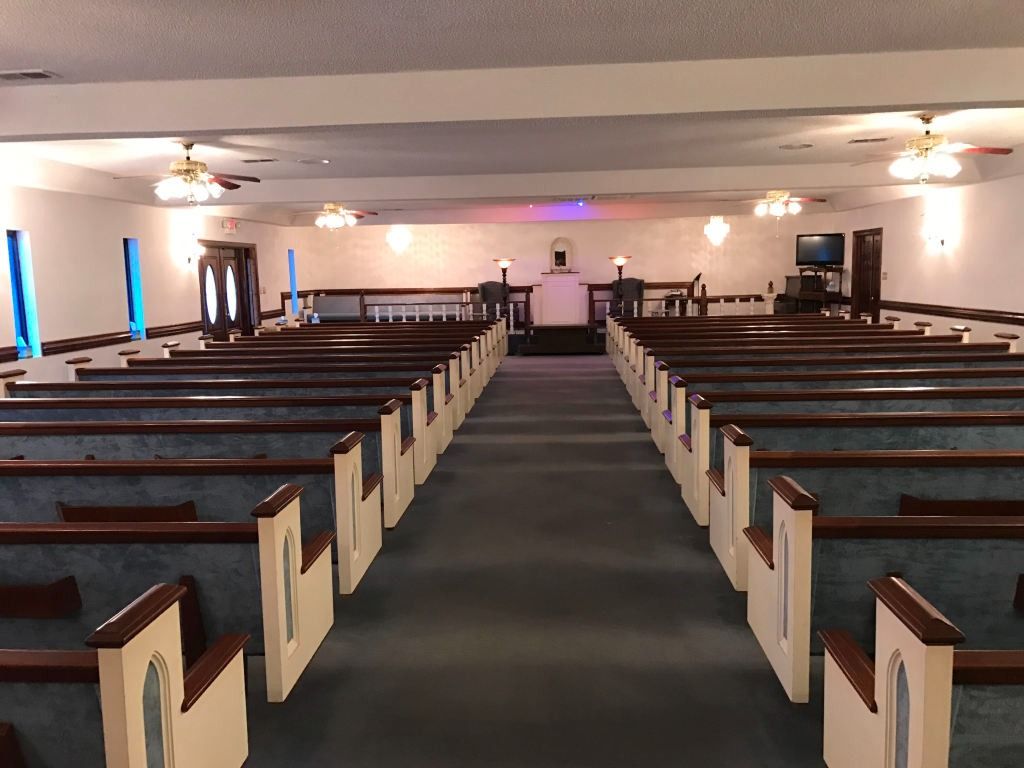 Interior of a church with rows of pews facing an altar.