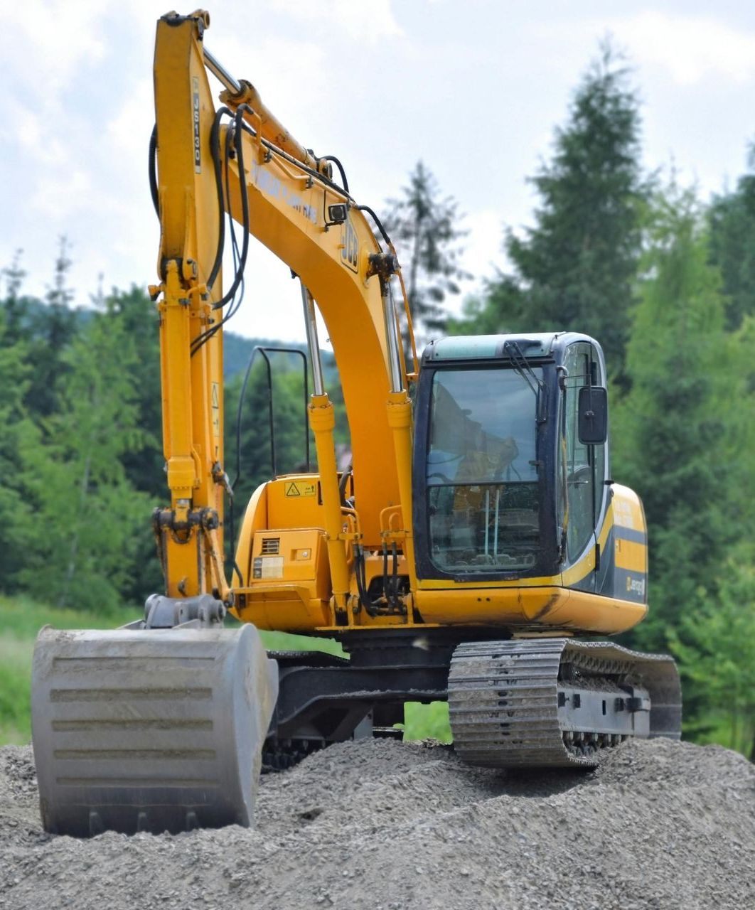 A yellow excavator is sitting on top of a pile of gravel in Southern Maryland.