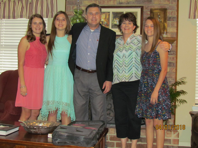 A family poses for a picture in front of a fireplace