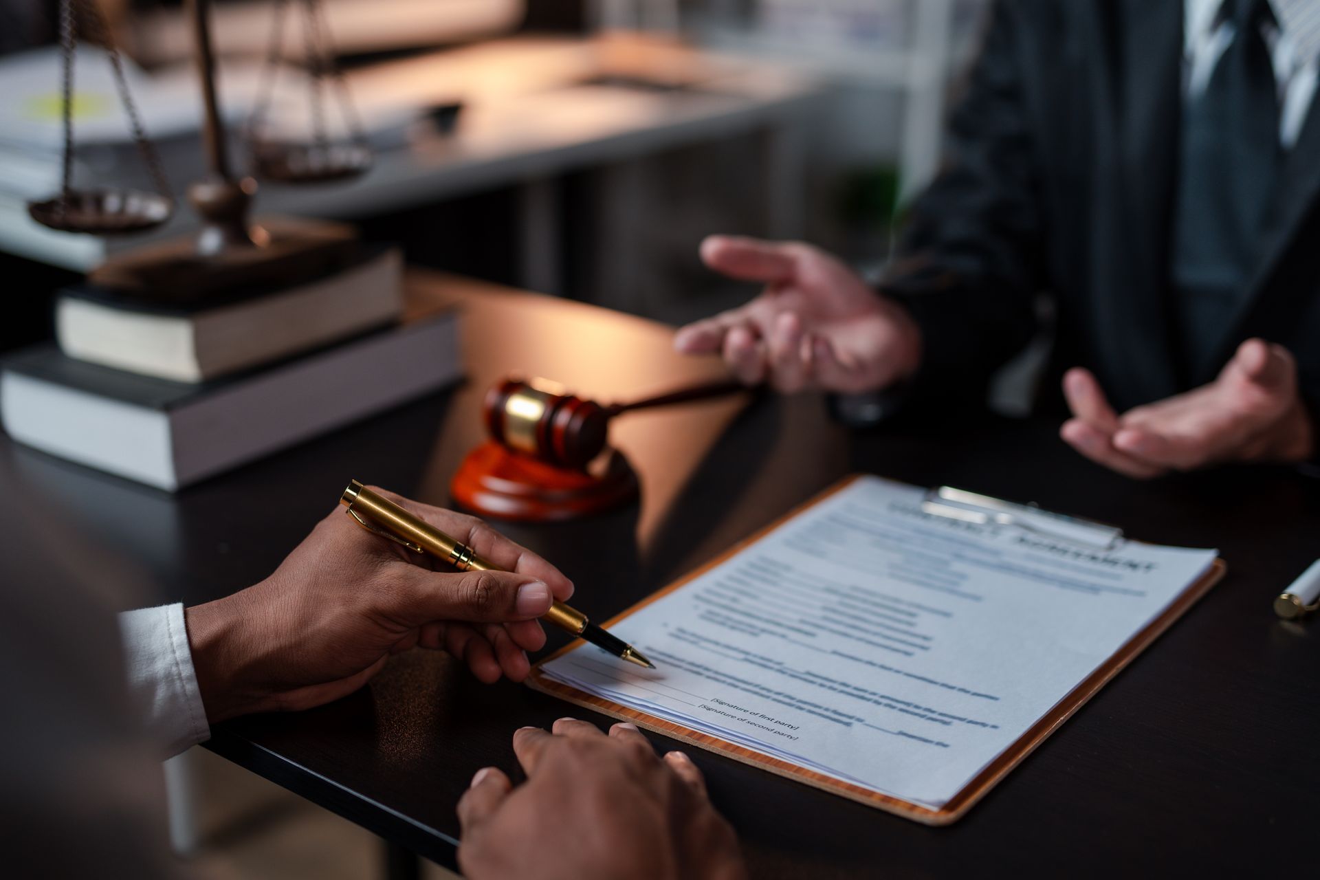 Two people reviewing a signed document at a desk with a pen and gavel nearby