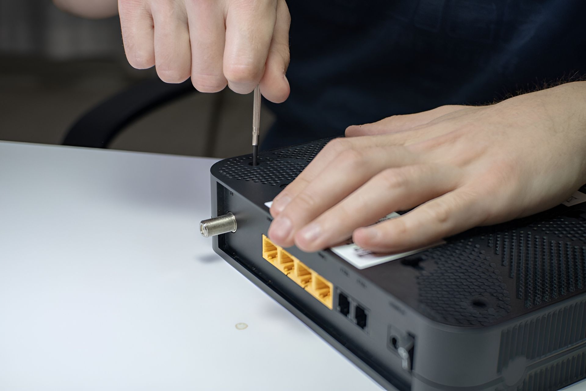 A Person is Fixing a Router With a Screwdriver — Direct Connect Services In Woombye, QLD