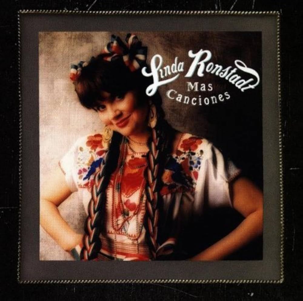 Linda Ronstadt album cover: Woman in embroidered shirt, braids, and bow, leaning against a wall. Text reads