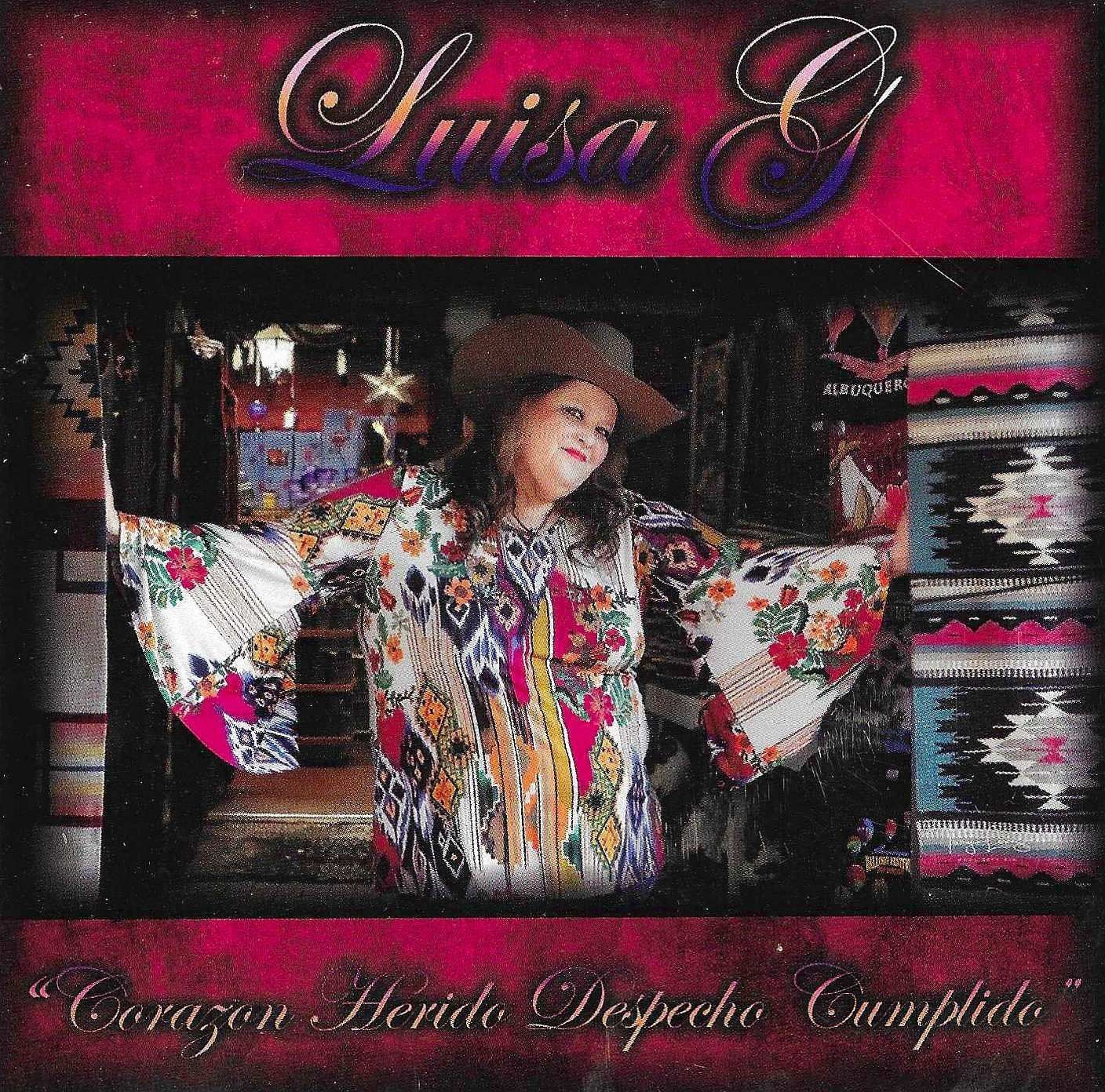 Album cover featuring Luisa G with arms outstretched, wearing colorful clothing, and a hat. She's framed by a doorway, with pink borders.